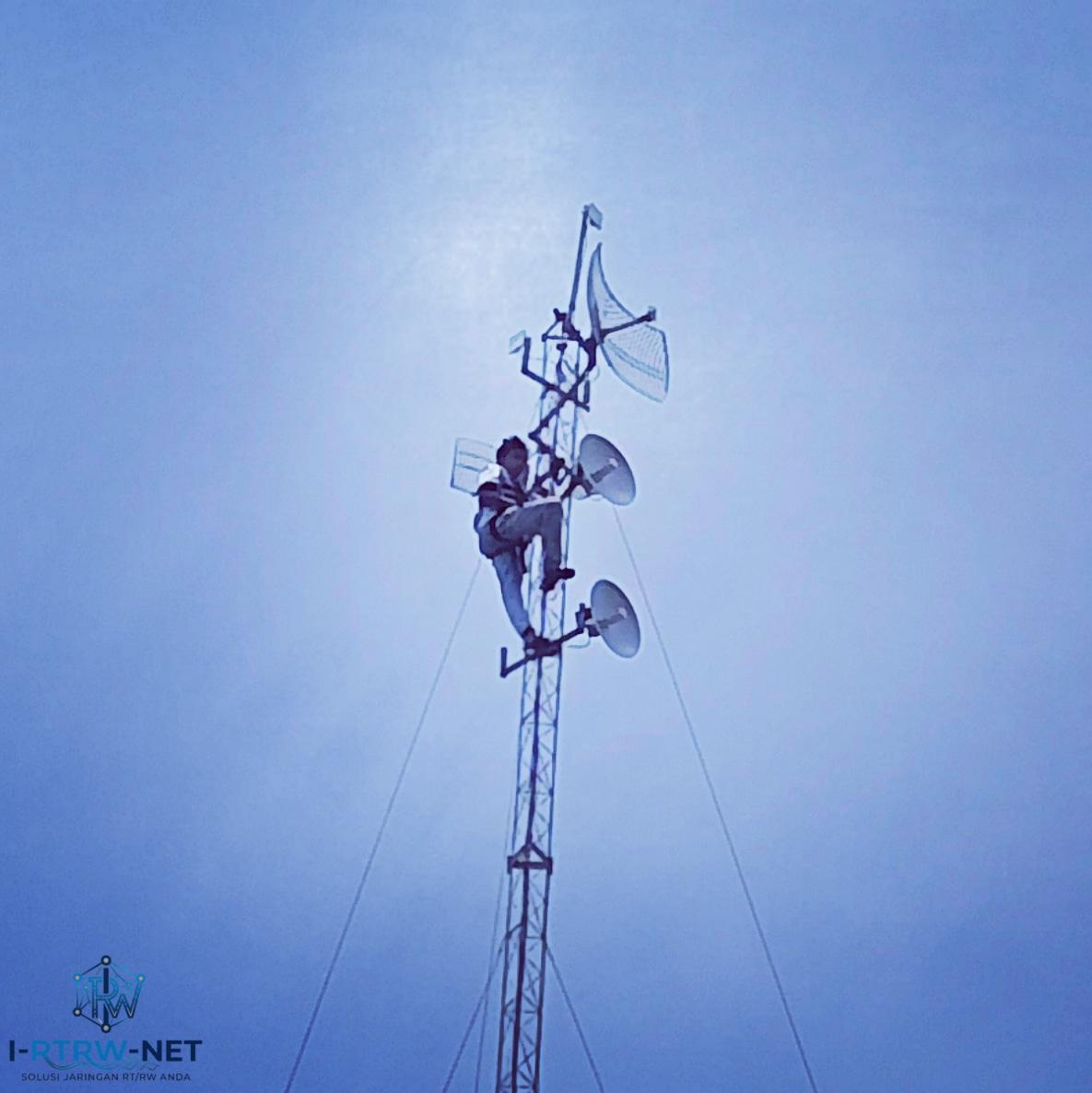 Seorang teknisi memperbaiki tower Internet